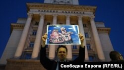 Протестиращ с карикатура на Иван Гешев и Сотир Цацаров