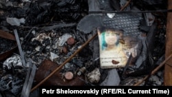 Обгоревший паспорт одного из пассажиров рейса MH17 на месте трагедии под Донецком, июль 2014 года