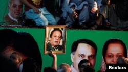 A supporter of former Pakistani prime minister Nawaz Sharif holds his picture