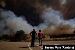 Местные жители наблюдают, как лесной пожар приближается к Конгосте, Испания, 11 августа 2025 года. Фото: Reuters