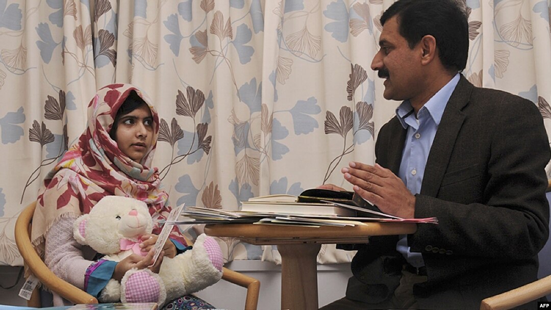 Malala Yousafzai (left) talks with her father Ziauddin at the Queen Elizabeth Hospital in Birmingham in November 2012.