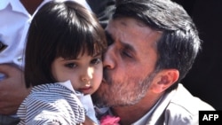 Ahmadinejad kisses a baby in Semnan.