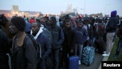 Полиция ходимлари лагердаги муҳожирларни Каледаги қайд этиш марказига пиёда кузатиб бормоқда. 2016 йил, 24 октябр