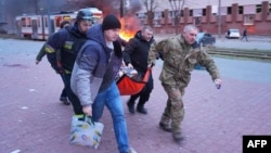 Civilians help emergency personnel carry a wounded person at the site of Russian strike on an industrial district of the city of Zaporizhzhya, Ukraine, on January 8.