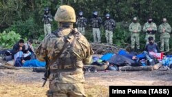 Polish soldiers and Afghan refugees near the village of Usnarz Gorny in eastern Poland.