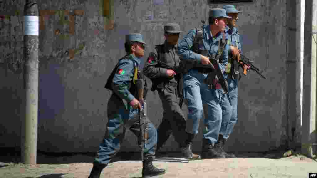 Afghan police advance toward one scene of the attacks in the capital. (AFP/JOHANNES EISELE)