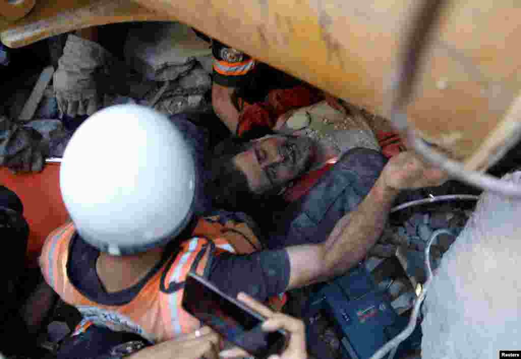 Спасатели извлекают человека из-под завалов после ударов авиации Израиля по городу Газа, 16 мая 2021. 16 мая палестинские медицинские службы заявили, что за прошедшую неделю в результате ударов Израиля по густонаселенному прибрежному анклаву Газы, были убиты 197 палестинцев, среди которых по меньшей мере 55 детей и 33 женщины. Более 1230 палестинцев получили ранения. Израиль заявил о 10 погибших в результате обстрела ХАМАСа, среди которых 5-летний мальчик и один израильский военный