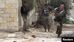 A member of the Free Syrian Army fires at a sniper as he runs for cover during clashes with pro-government forces in Harem in the Idlib Governorate on October 25.