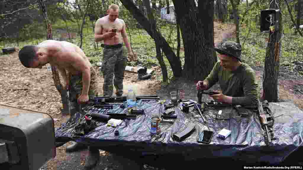 Українські військові у теплу весняну погоду чистять зброю і готуються до вечора