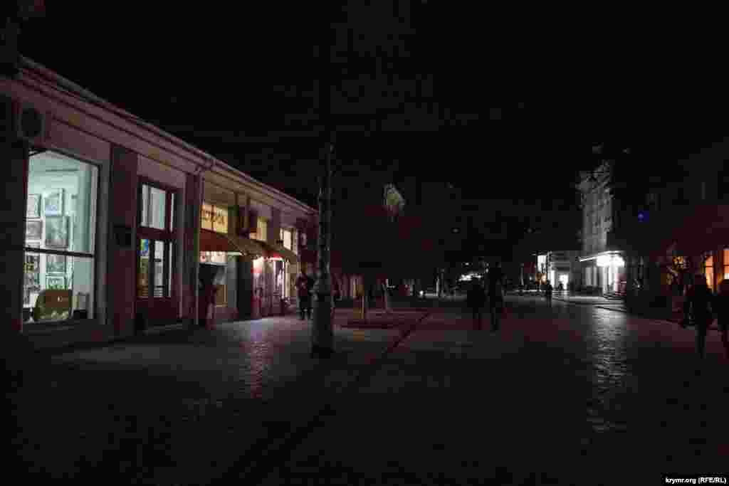 Вітрини деяких магазинів і кафе освітлюють вулиці своїм світлом