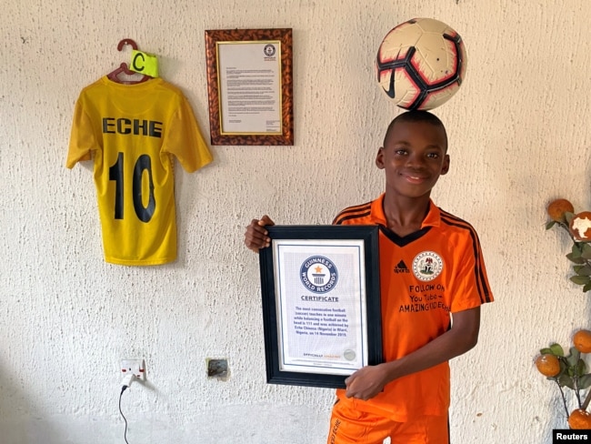 Dymbëdhjetë vjeçari Chinonso Eche mban një top në kokë ndërsa pozon me pllakën e tij të Rekordit Botëror Guinness në shtëpinë e tij në Warri, Nigeri, 9 janar 2021.
