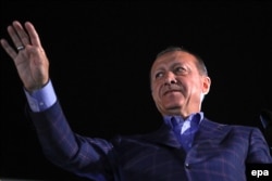 Turkish President Recep Tayyip Erdogan waves to his supporters during a rally after he declared victory in the constitutional referendum.