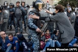 Протестувальниця намагається зупинити поліцейського, коли спецсили поліції блокують вхід до будівлі уряду, Єреван, 19 квітня 2018 року