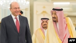 This handout photograph released by the Iraqi President's Office on November 18, 2018 shows President Barham Saleh (L) being received by Saudi Arabia's King Salman in the Saudi capital Riyadh. (Photo by - / Iraqi Presidency Media Office / AFP) 