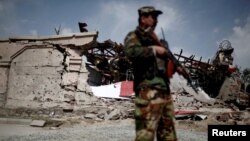 Представник афганських сил безпеки стоїть перед зруйнованою будівлею, ілюстративне фото 