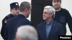 Ex-President Serzh Sarkisian (right) appears in court in Yerevan on February 25.