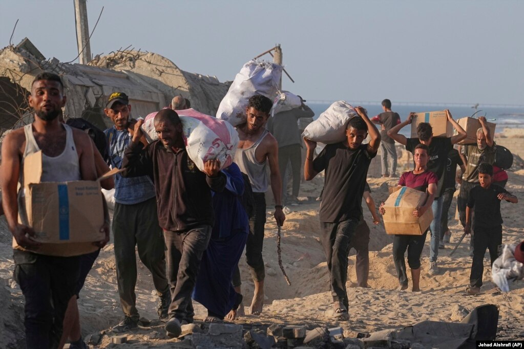 Banorë të Gazës të ngarkuar me ndihma.