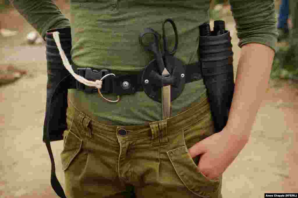Didi Aaslund, a Dutch volunteer who helped design the bag and runs the class with Floor, shows off her toolbelt, made from the straps of a life jacket and the material and lifeline holder of a migrant boat. 