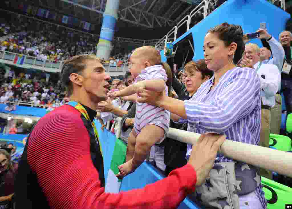 U.S. swimmer Michael Phelps (L) with his fiancee Nicole Johnson (R) and their son Boomer (C) after he received the gold medal in the men&#39;s 200-meter butterfly competition.