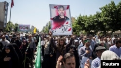 People attend the funeral of victims of the June 7 attack on June 9.