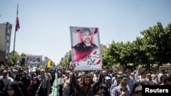 People attend the funeral of the victims killed in June 7 attacks at the Iranian parliament and Ayatollah Khomeini's mausoleum.