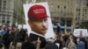Дэманстрант трымае плякат з выявай Уладзімера Пуціна, на кепцы якога напісаны лёзунг Дональда Трампа, ЗША, архіўнае фота