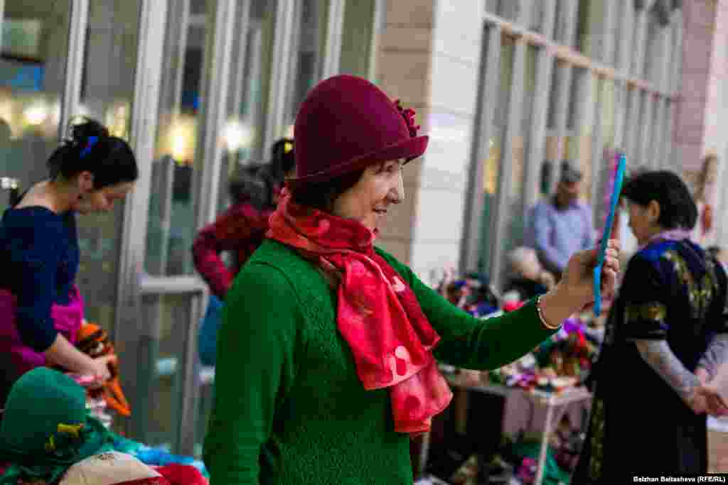 Женщина примерят шарф ручной работы.