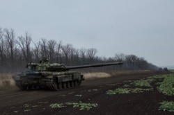 Ukrainian tanks rumble back to their base after recent training exercises in eastern Ukraine.