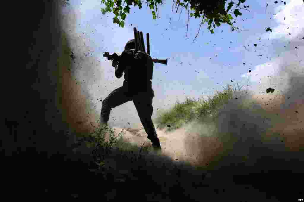 An Afghan National Army soldier fires his weapon after an attack by Islamic State militants in the Chapahar district of Nangarhar Province. (epa/Ghulamullah Habibi)