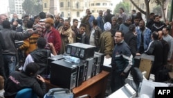 Египет -- Люди собрались вокруг товаров из разграбленного супермаркета Аркадия в Кире, 29 января 2011 г.