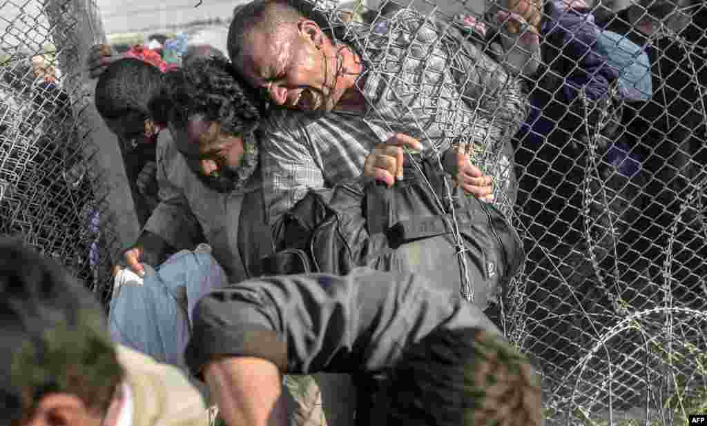 Syrians fleeing the war pass through border fences to enter Turkish territory illegally, near the Turkish border crossing at Akcakale in Sanliurfa Province. (AFP/Bulent Kilic)