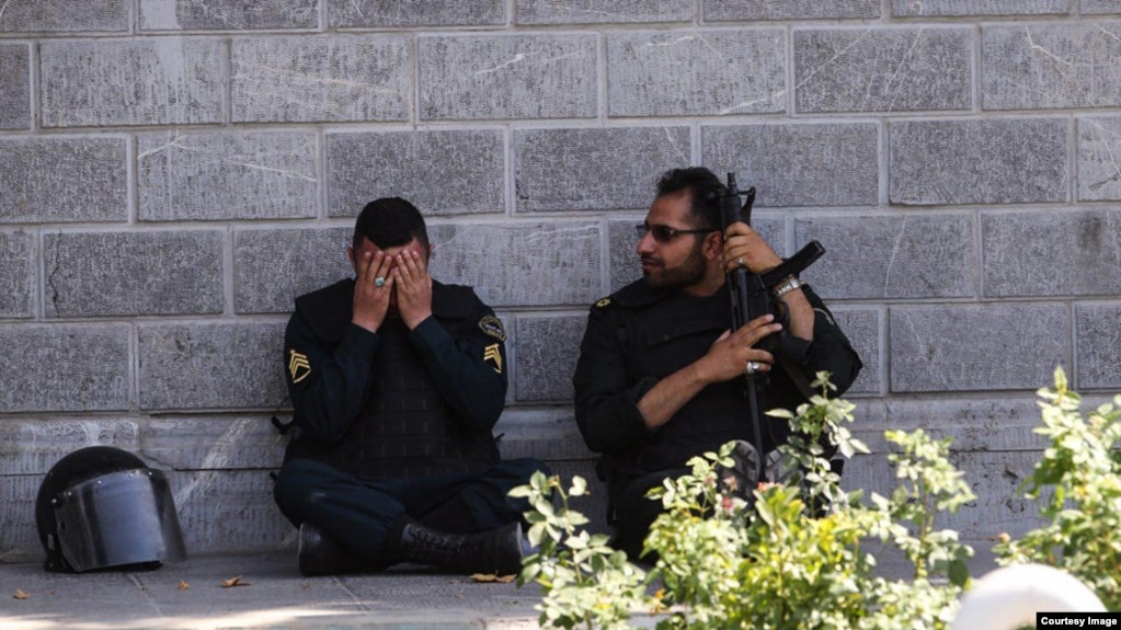 A member of the Iranian security forces reacts during a pause in the response to the Islamic State attack on the Iranian parliament.