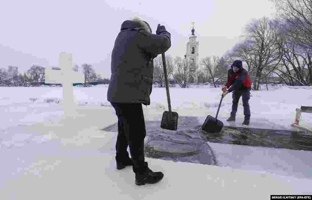 Russian Orthodox believers cut a cross-shaped Epiphany ice hole in the village of Velyaminovo outside Moscow.