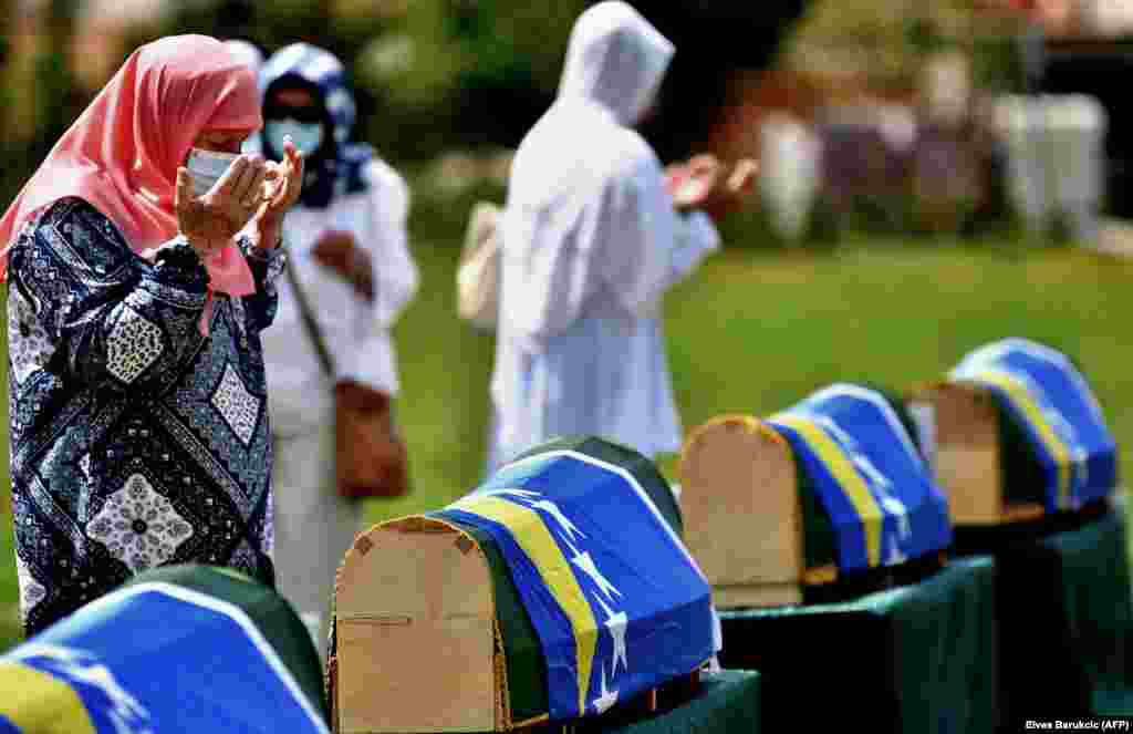 Bosnian Muslim women, survivors of a massacre in the western Bosnian town of Prijedor in 1992, pray and mourn near the caskets of relatives in the village of Kamicani. The bodies were identified as those belonging to Bosnian non-Serbs who went missing in 1992, only to be found buried in several mass graves years after the war ended. (AFP/Elvis Barukcic)