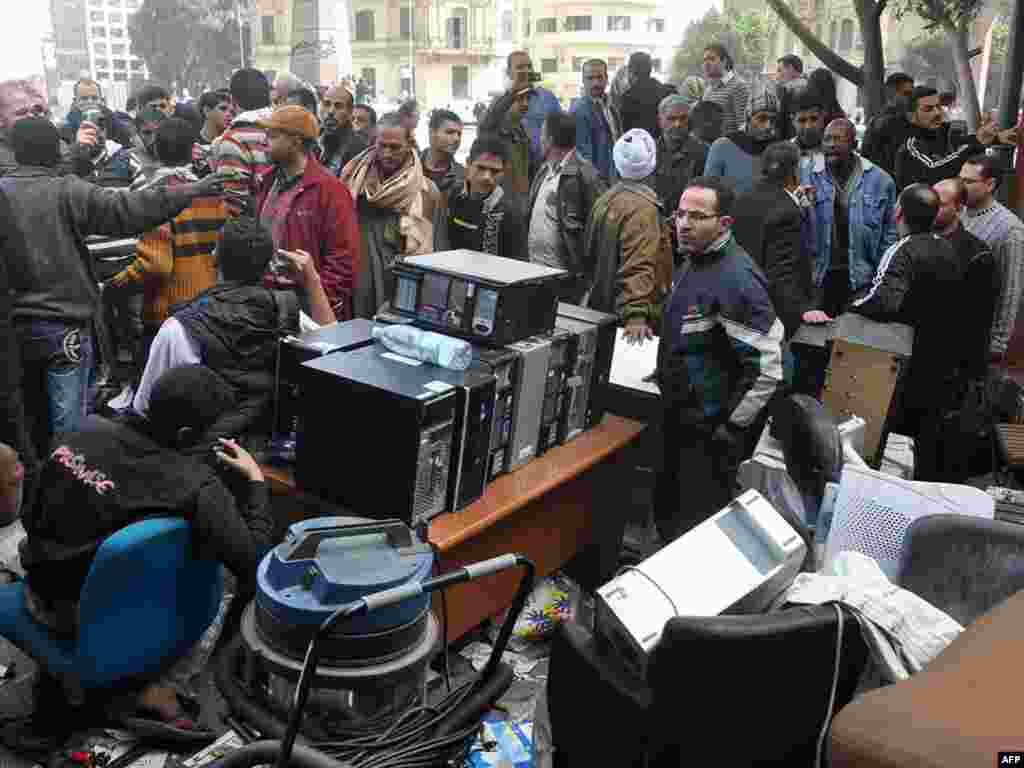 Egyptians surround goods looted from the Arcadia mall in Cairo on January 29 as looting mounted.