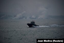 Brod Španjolske civilne garde prolazi pored dima koji se diže u pozadini nakon erupcije vulkana na Kanarskom otoku La Palma, 1. oktobar 2021.