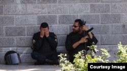 A member of the Iranian security forces reacts during a pause in the response to the Islamic State attack on the Iranian parliament.