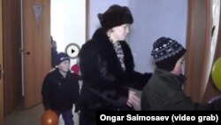 Многодетная мать Шолпан Сайымова с детьми входят в свою новую квартиру. Кызылорда, 30 декабря 2015 года. 