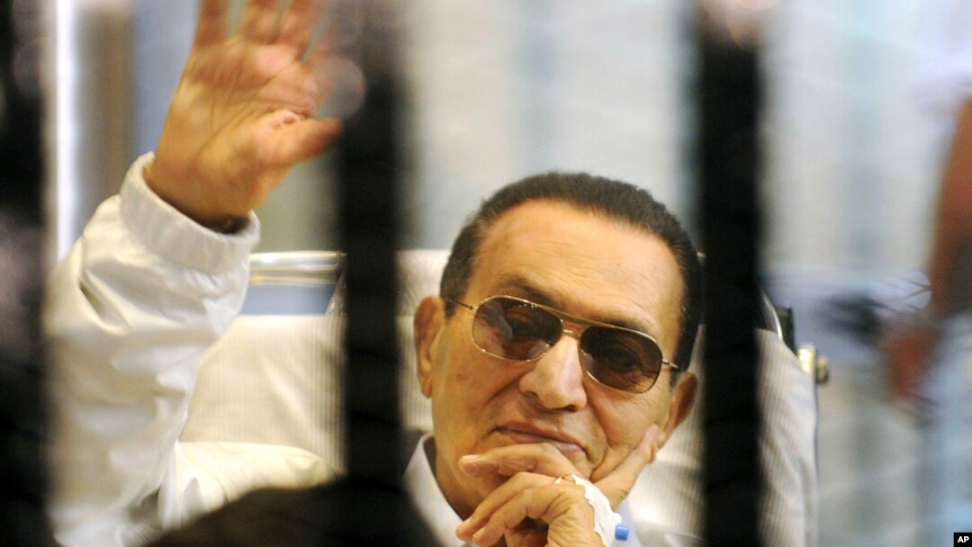 Bivši egipatski predsjednik Hosni Mubarak maše svojim pristalicama iza rešetaka na saslušanju tokom obnovljenog suđenja u Kairu, 13. aprila 2013.