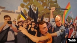 Одна из картин Алтунина с прорезями для голов изображает преследование полицией гомосексуалистов. Санкт-Петербург, 23 августа 2013 года.