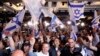 Supporters of the Blue and White (Kahol Lavan) political alliance celebrate after watching a TV poll at the alliance headquarters in Tel Aviv on April 9, 2019.