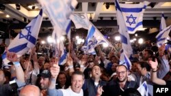 Supporters of the Blue and White (Kahol Lavan) political alliance celebrate after watching a TV poll at the alliance headquarters in Tel Aviv on April 9, 2019.