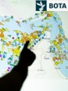 Një grua iraniane ec pranë një murali në një rrugë në Teheran.