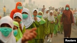 Students wear masks as they celebrate "Khatam" in haze-hit Dumai, in Indonesia's Riau province in June 2013.