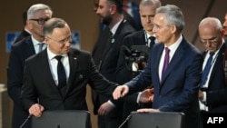 NATO Secretary-General Jens Stoltenberg (right) and Polish President Andrzej Duda participate in a working session of the NATO summit in Washington on July 11.