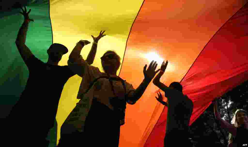 People take part in a gay-pride parade under a huge rainbow flag in Belgrade on September 18. (AFP/Oliver Bunic)