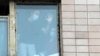 Люди в лицевых масках видны в окне здания, помещенного в карантин, в общежитии Северо-Западного государственного медицинского университета им. И.И. Мечникова