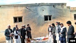 Afghanistan -- Afghans stand around the body of one of the ten victims killed in a missile attack on a Mosque in the village of Attal in Sayeed Abad District of Maidan Wardak Province, December 4, 2015