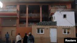 Afghan policemen keep watch outside the house of an Afghan member of parliament. It was attacked by the Taliban on December 21.