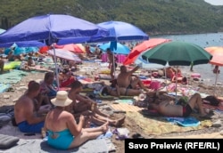 Pushuesit në kërkim të hijes në një plazh në Tivar.